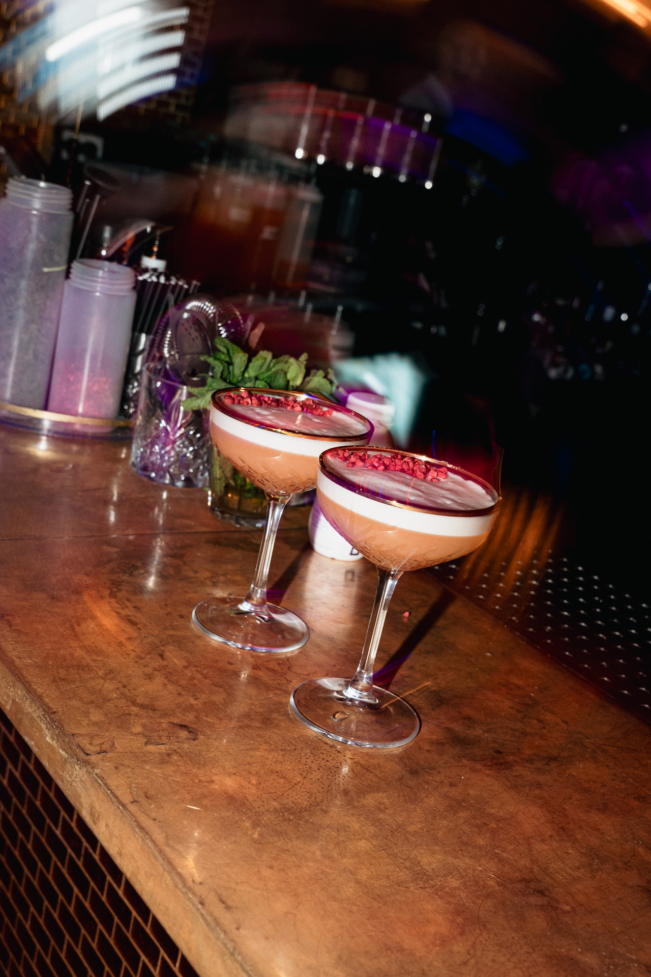 A finished cocktail is placed onto a tray during service